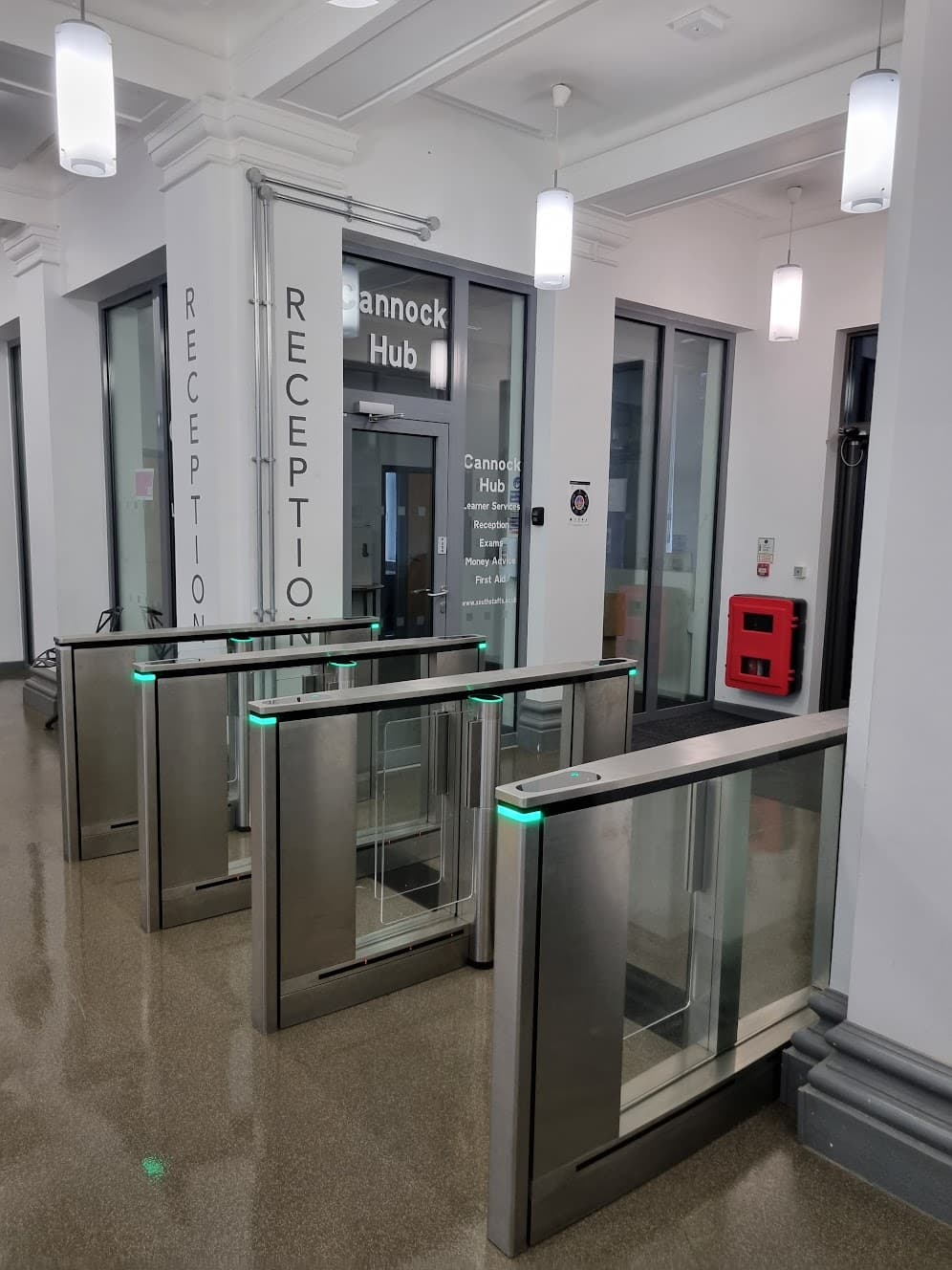 Three-lane speed-gate access control system installed at the reception entrance of South Staffordshire College's Cannock Campus, with Cannock Hub signage visible beyond.